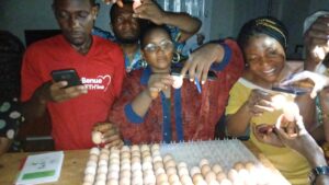 Candling eggs to identify quitters, winners, and yolkers (non-fertile eggs) during the Sustainable Solar Egg Hatchery and Entrepreneurship Training.